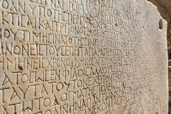 Fragment of ancient greek inscription, carved on marble block at the archaeological site of Ephesus. Selcuk, Turkey (Turkiye).