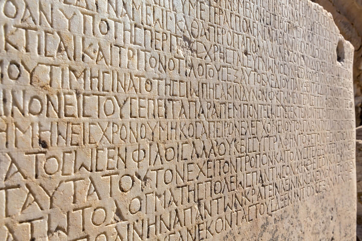 Fragment of ancient greek inscription, carved on marble block at the archaeological site of Ephesus. Selcuk, Turkey (Turkiye).